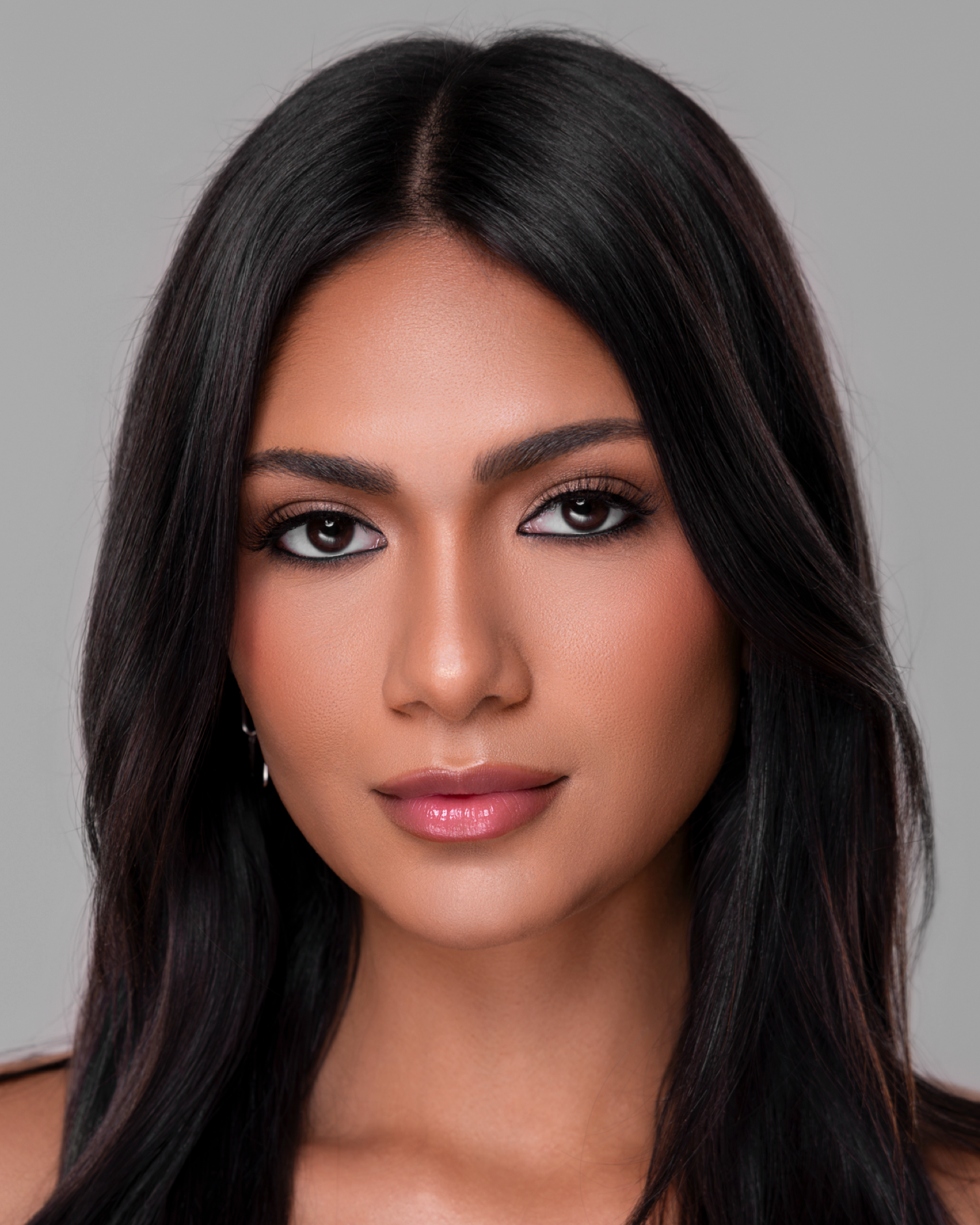 Woman with long dark hair against a gray background